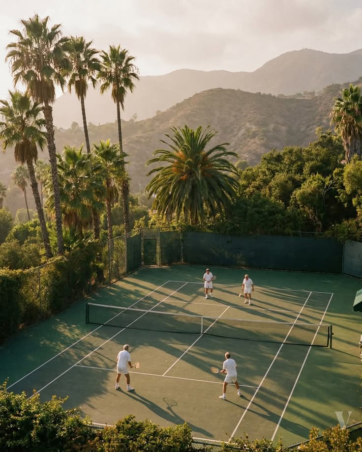 Doubles on a court ringed by palms and mountains